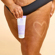 Model holding the Miracle Tan Eraser and showing results of product on leg